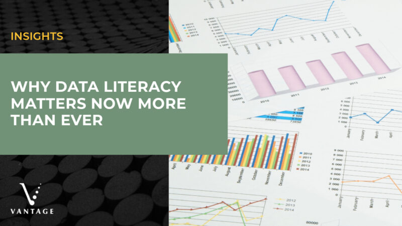 Pile of papers with charts and graphs. Text reads, "Insights: Why Data Literacy Matters Now More Than Ever" with Vantage logo.