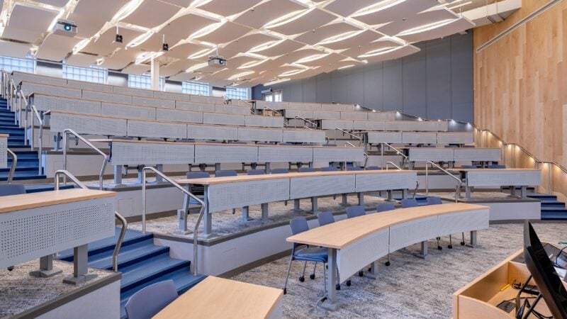 A brightly lit, modern classroom with stadium-style seating